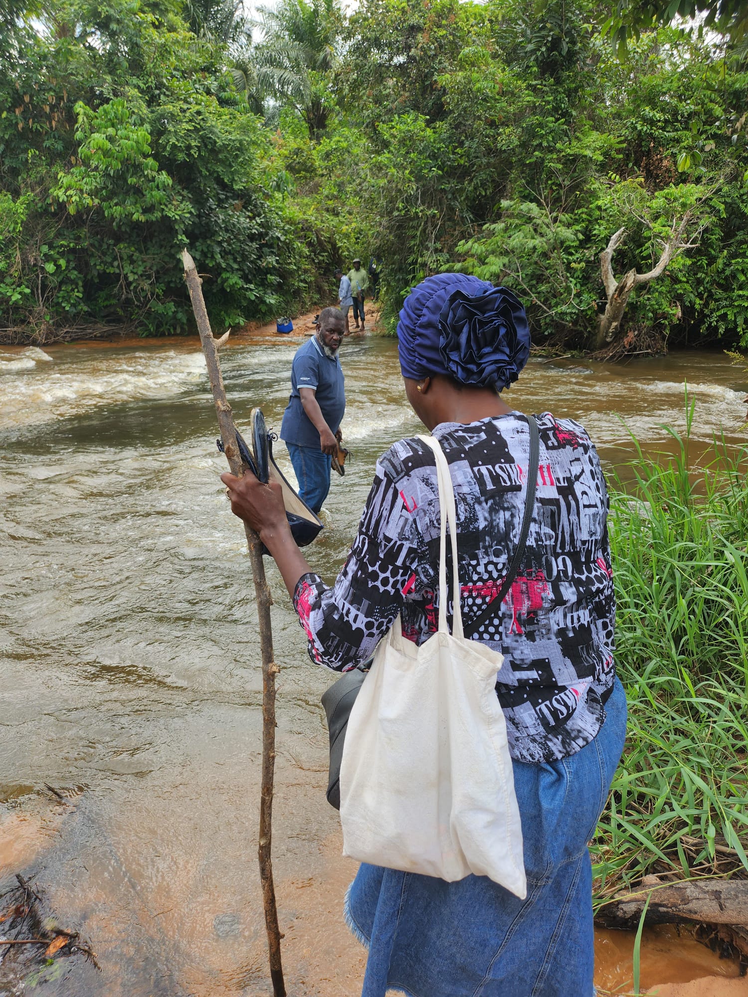 Une femme traverse une rivière à Madimba Mao, une localité entourée de vastes terres agricoles encore inexploitées. Malgré la richesse en eau et en sols fertiles, la population locale, surtout les femmes et les enfants, souffre encore de malnutrition et d’insécurité alimentaire.